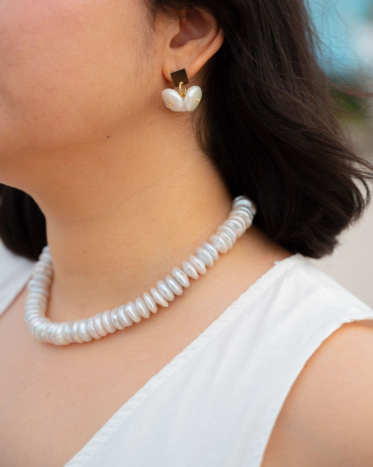 Coin Pearl Earrings worn by a model, square gold stud with a cluster of coin pearls, paired with the Agua necklace