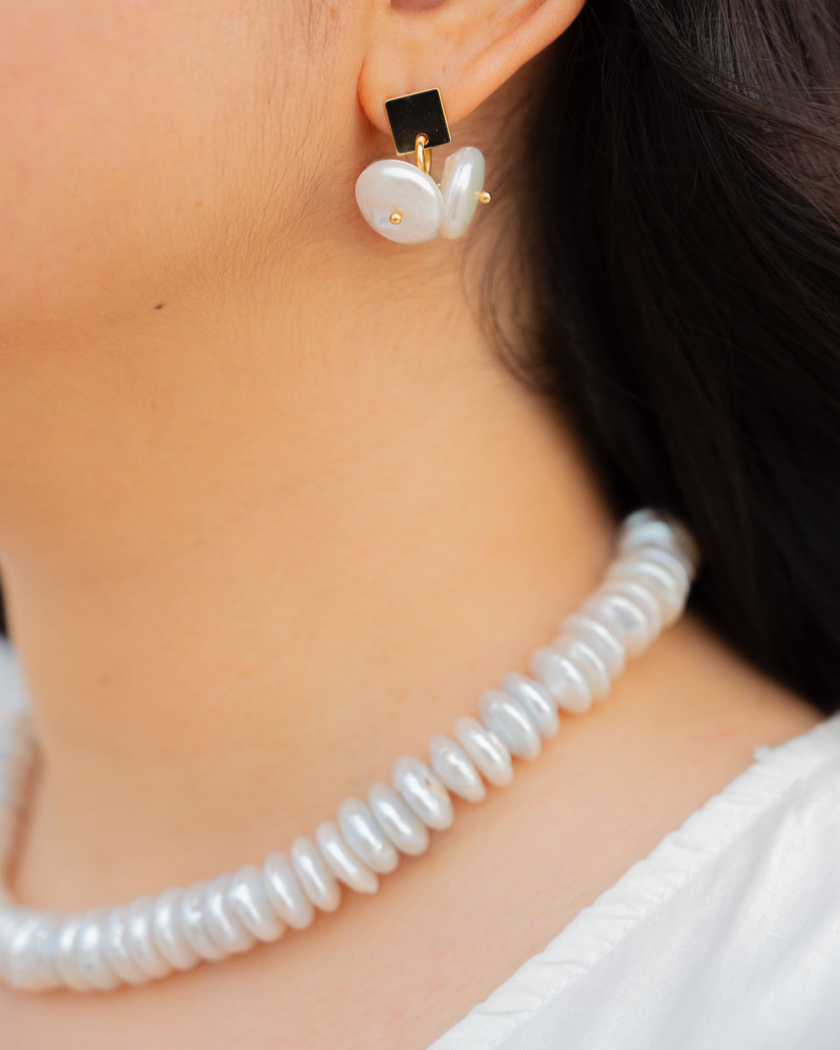 Coin Pearl Earrings worn by a model, square gold stud with a cluster of coin pearls, paired with the Agua necklace